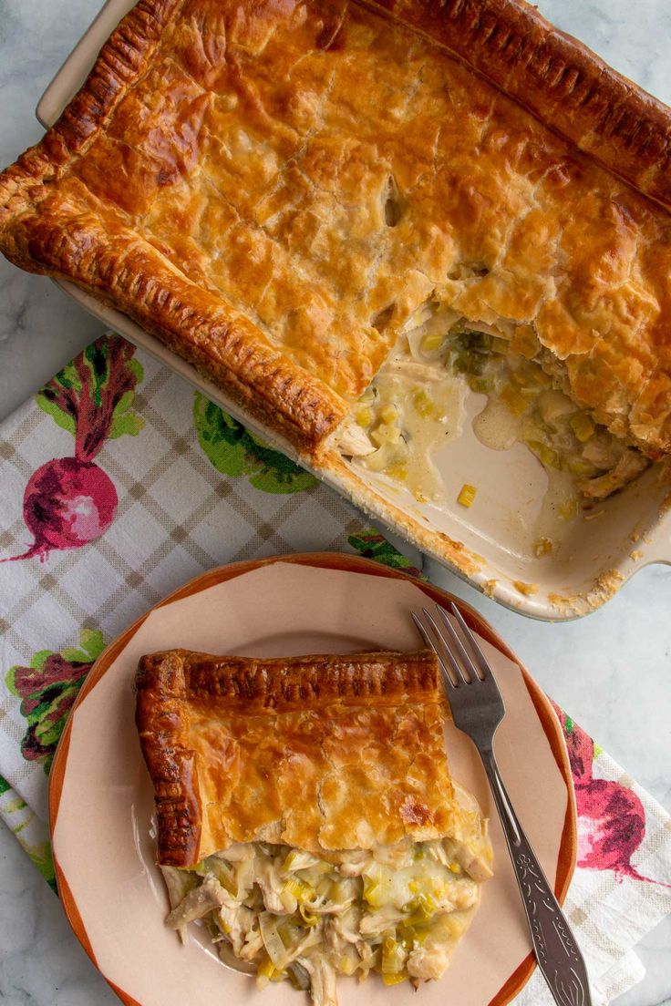 a piece of pie on a plate with a fork next to it and another dish in the background