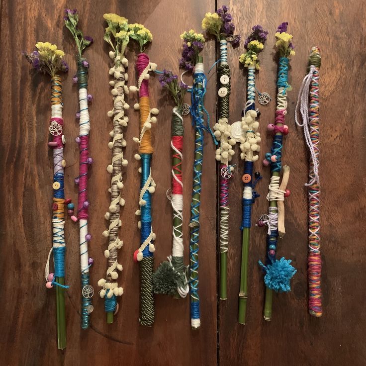 several different types of beads and flowers on a wooden surface with one bead in the middle