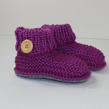 a pair of purple knitted boots with a button