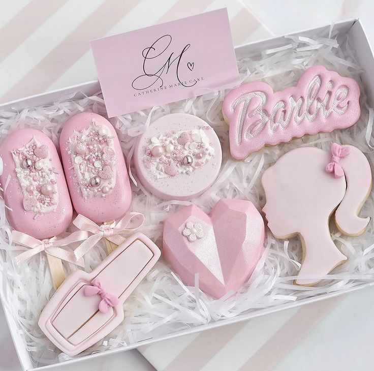 a box filled with pink decorated cookies in it