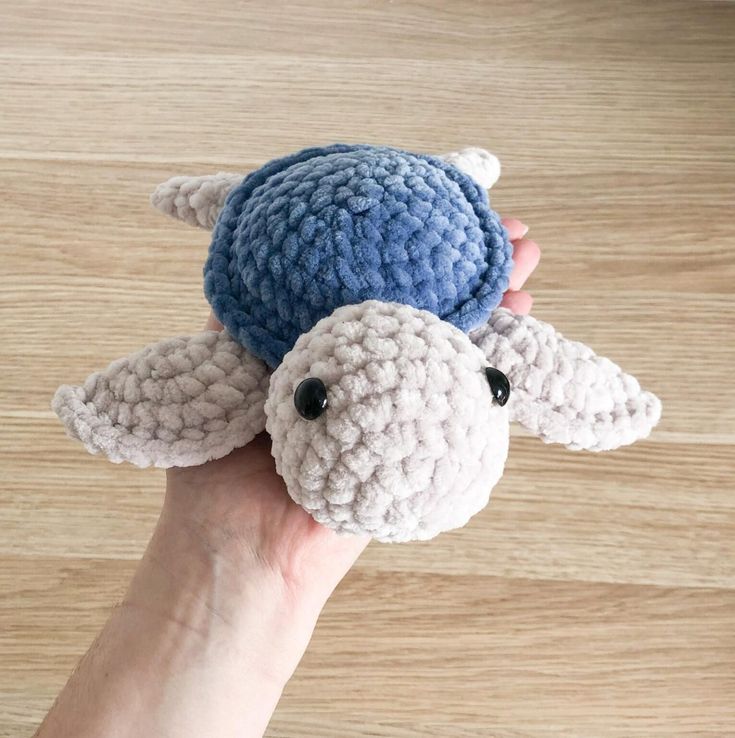 a hand holding a small crocheted stuffed animal