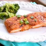 a white plate topped with fish and broccoli