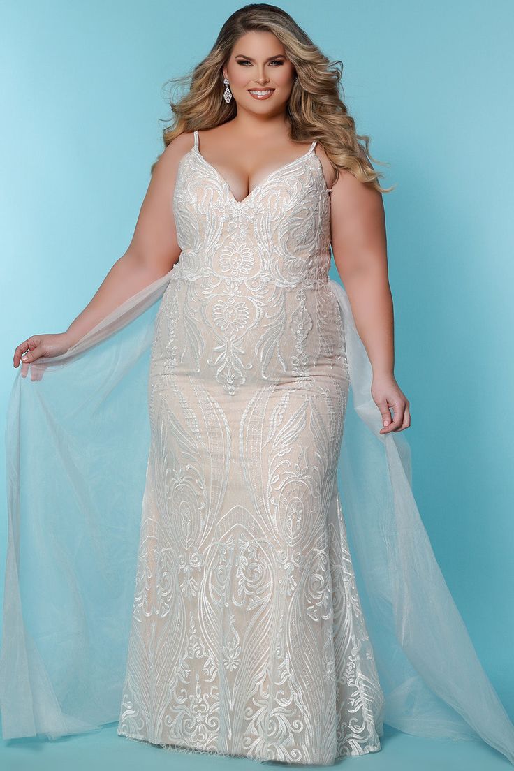 a woman in a plus size wedding dress posing for the camera with her hands on her hips