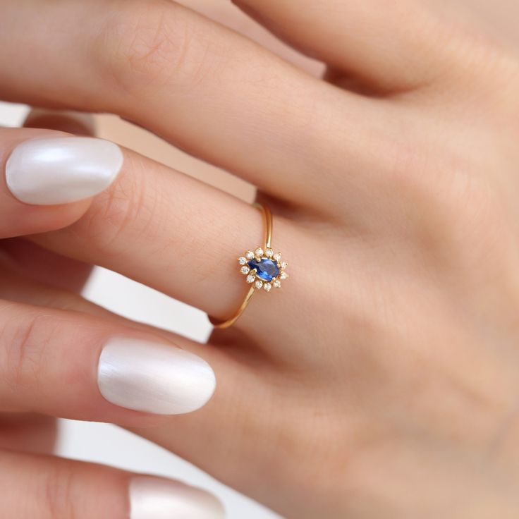 Discover the timeless elegance of our Sapphire Drop Ring, a perfect blend of luxury and charm. Crafted from 14k solid gold, this exquisite ring features a stunning sapphire, the birthstone for September, complemented by sparkling diamonds that enhance its allure. The drop design adds a touch of sophistication, making it not only a captivating accessory but also a piece rich in symbolism and history. Specially designed for those who cherish unique jewelry, this ring makes an ideal gift for birthd Dainty Promise Jewelry With Halo Design, Dainty Halo Design Jewelry For Promise, Fine Jewelry Cluster Ring With Birthstone For Promise, Dainty 14k Gold Cluster Ring With Gemstone, Fine Jewelry 14k Gold Cluster Promise Ring, Sapphire Birthstone Ring In 14k Gold, Fine Jewelry 14k Gold Cluster Ring For Promise, Promise Cluster Ring With Birthstone In Fine Jewelry Style, 14k Gold Cluster Ring For Promise Occasions