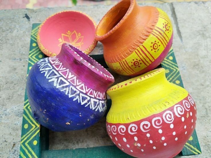 three colorful vases sitting on top of a green tray