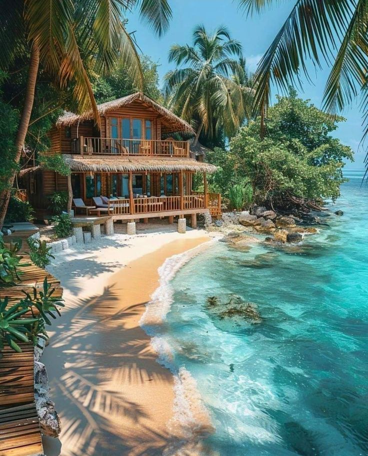 an image of a house on the beach that is surrounded by palm trees and water