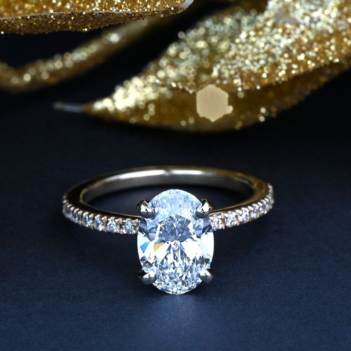 an oval cut diamond ring with pave set shoulders