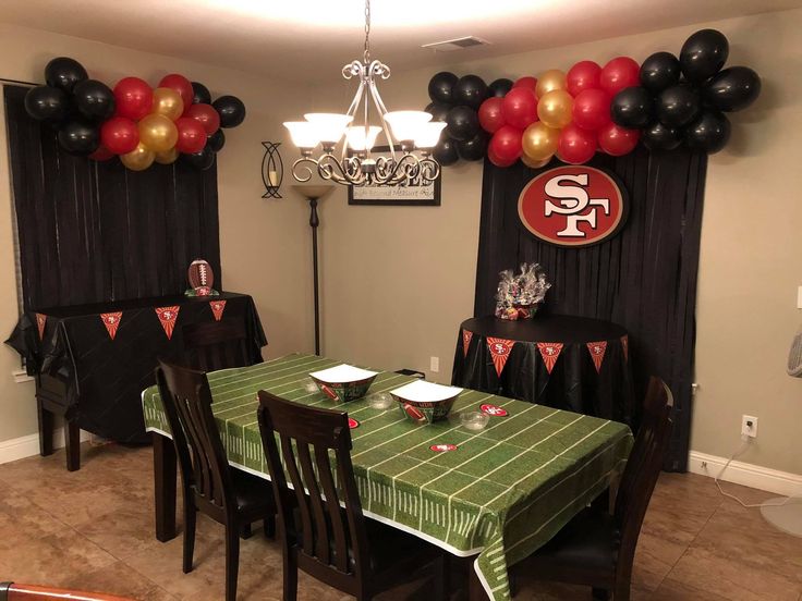 a football themed party with balloons and table cloths on the dining room table set for two