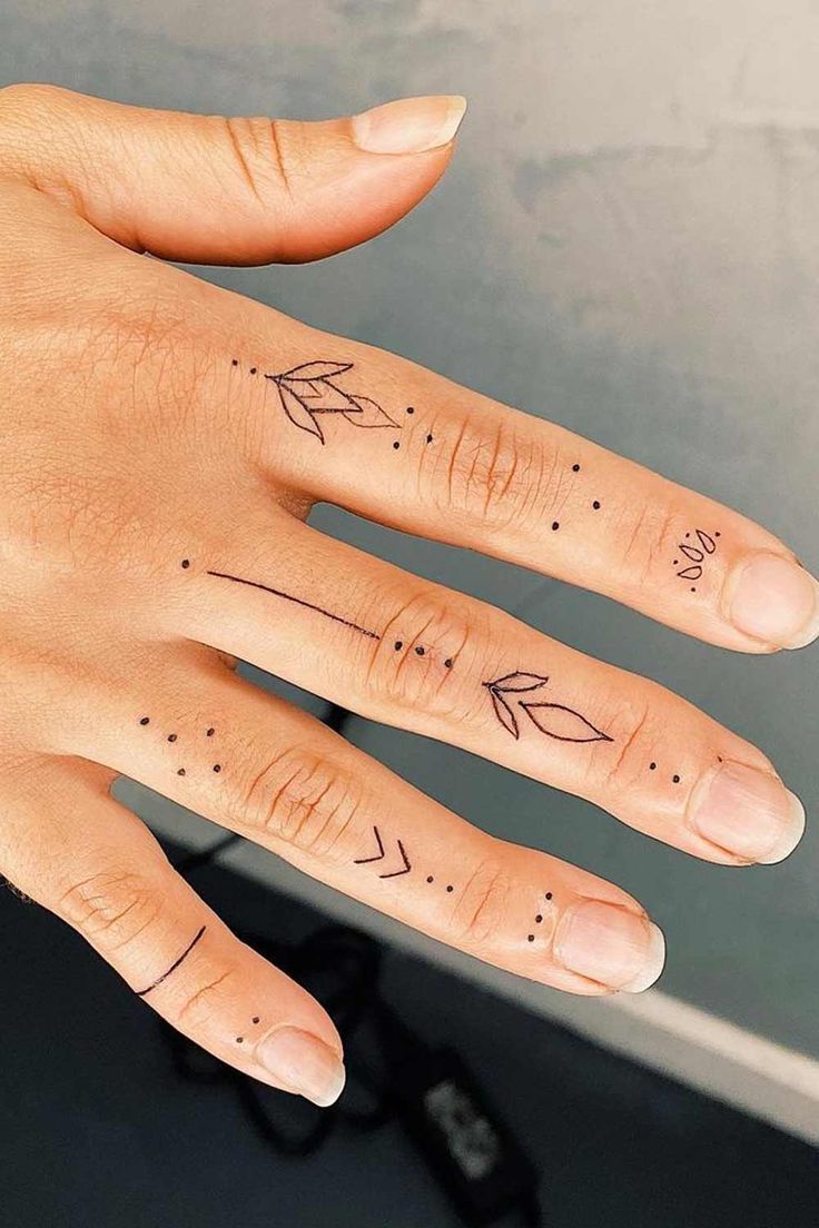 a woman's hand with two finger tattoos on her left and the other one has an arrow