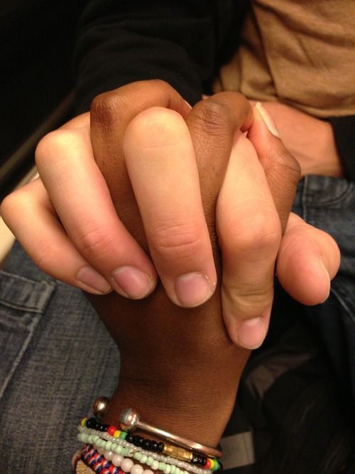 two people holding hands with bracelets on their wrists