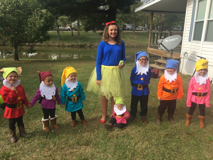 a group of children dressed in costumes standing on the grass with one child smiling at the camera