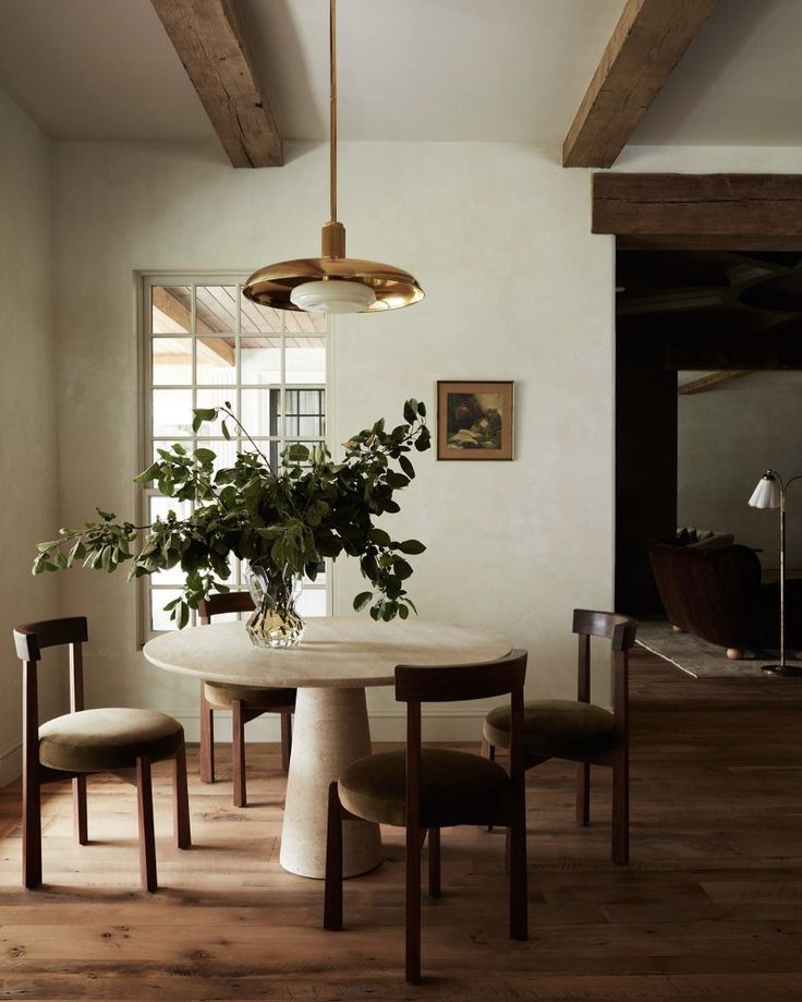 a dining room table with chairs and a potted plant on the top of it