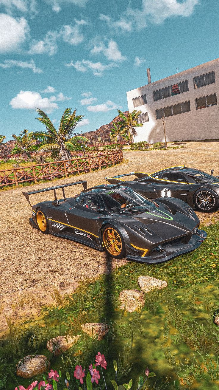 two black sports cars parked next to each other in front of a large white building