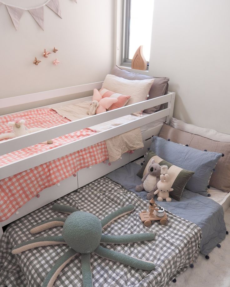 a child's room with two bunk beds and stuffed animals on the bedding