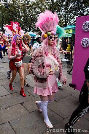 a group of people walking down a street next to each other wearing costumes and headgear