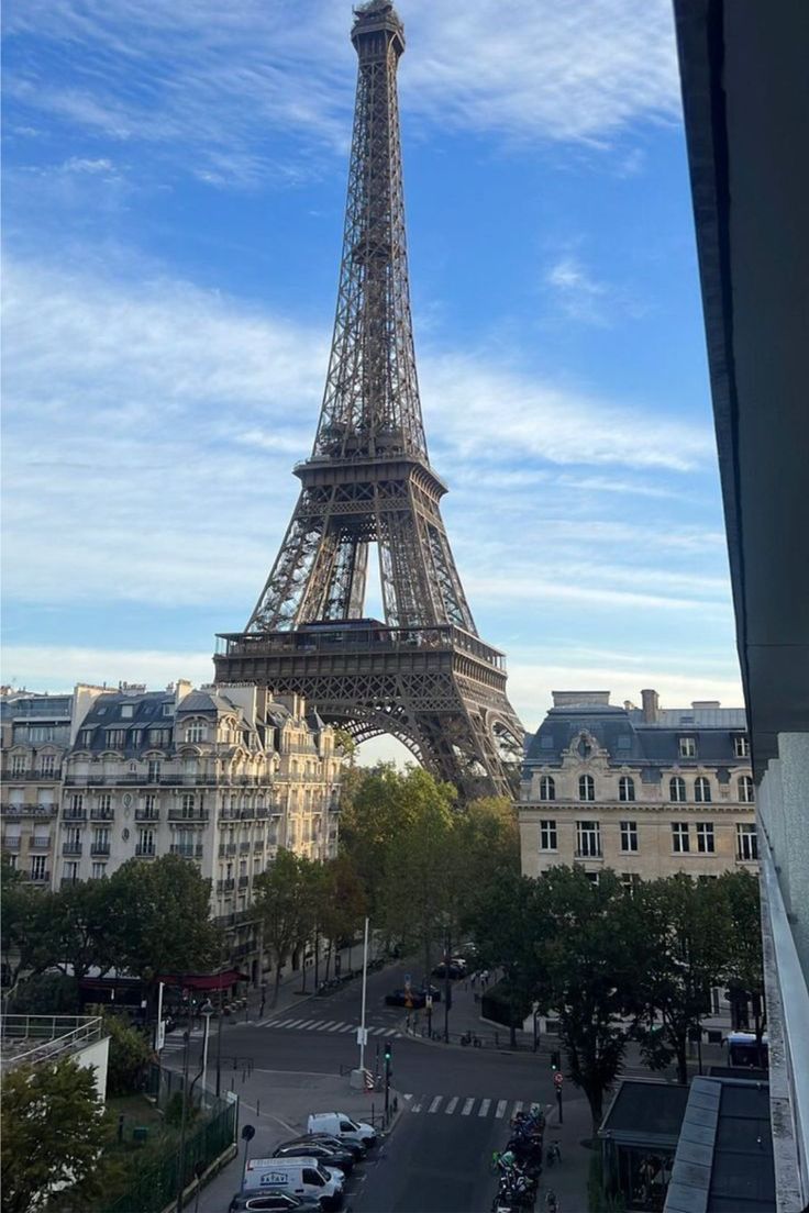 the eiffel tower in paris, france is seen from an apartment window with cars parked below it