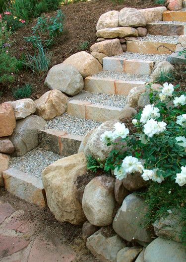 stone steps lead up to white flowers in the garden