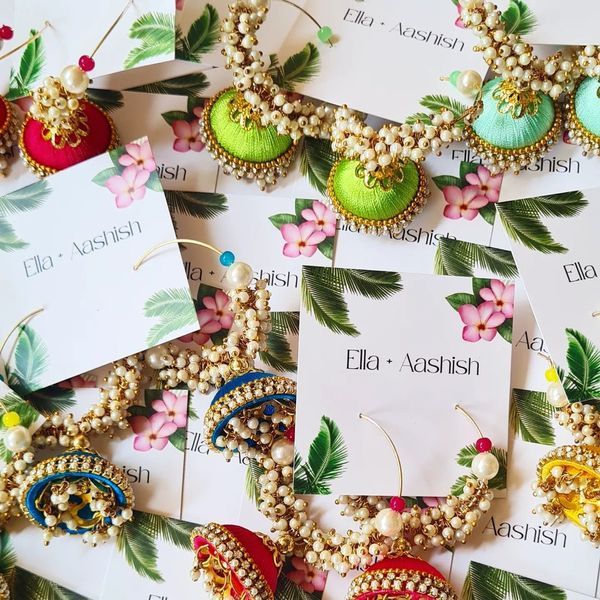 many different types of earrings are laying on top of each other with cards attached to them