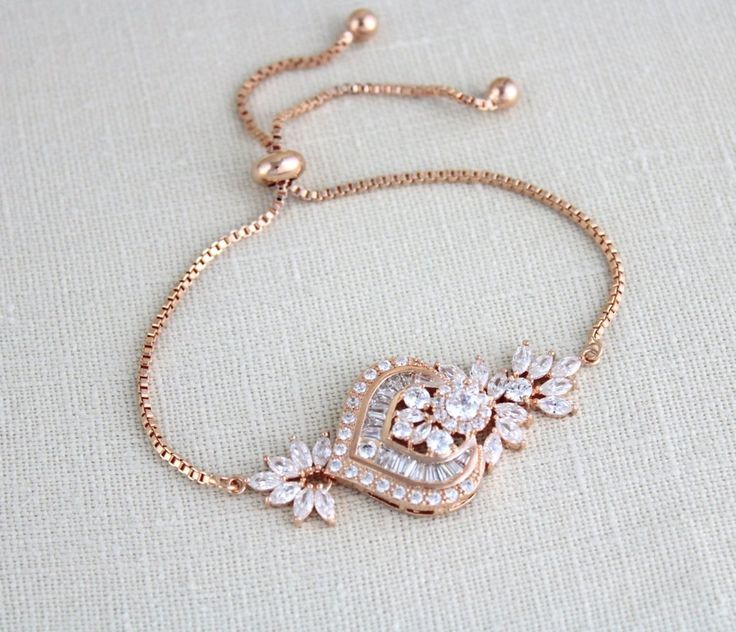 There’s nothing like a bracelet to incorporate in your wedding look and make that wedding ring pop even more! This pretty rose gold cubic zirconia bridal bracelet is adjustable and it will complement elegant looks like nothing else! The unique design and the way in which it flawlessly incorporates both CZ and rose gold will charm you in an instant!Created with an adjustable slide chain to fit most wrist sizes.- Created with Premium cubic zirconia stones - Rose gold plated over brass, nickel free Gold Bracelet Indian, Art Deco Bridesmaids, Gold Bridesmaid Necklace, Bridal Bracelets, Gold Bridal Necklace, Rose Gold Pendant Necklace, Slide Bracelet, Rose Gold Bridal, Bridal Fashion Jewelry