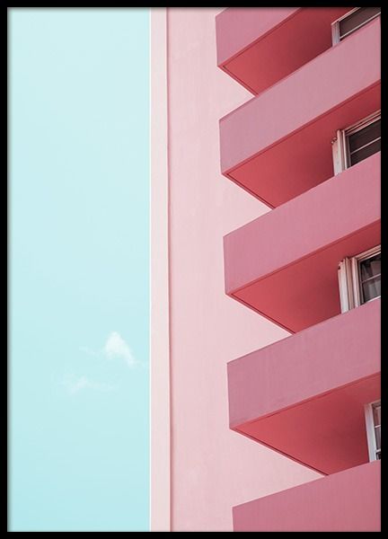 an apartment building with pink balconies and a blue sky in the back ground