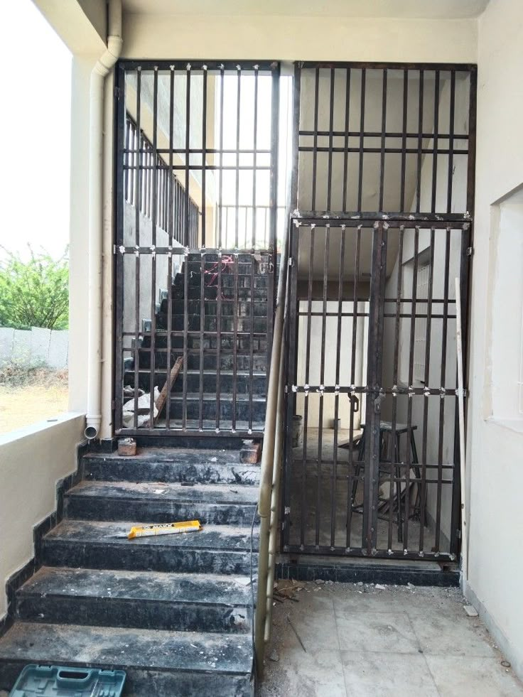 a set of stairs leading up to a jail cell with bars on the top and bottom