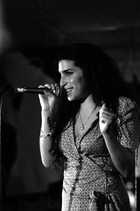 a woman singing into a microphone on stage