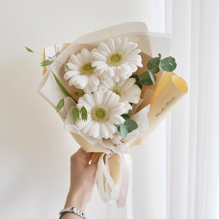 a person holding a bouquet of white flowers