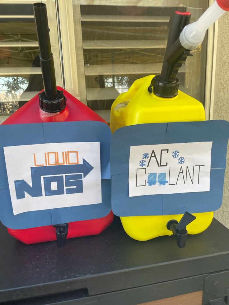 two yellow and red gas cans sitting next to each other on top of a table