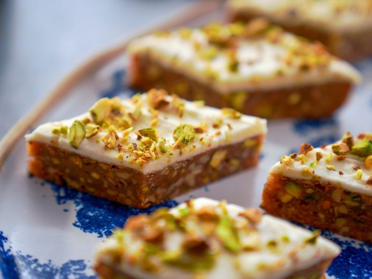 several pieces of cake sitting on a blue and white plate with nuts around the edges