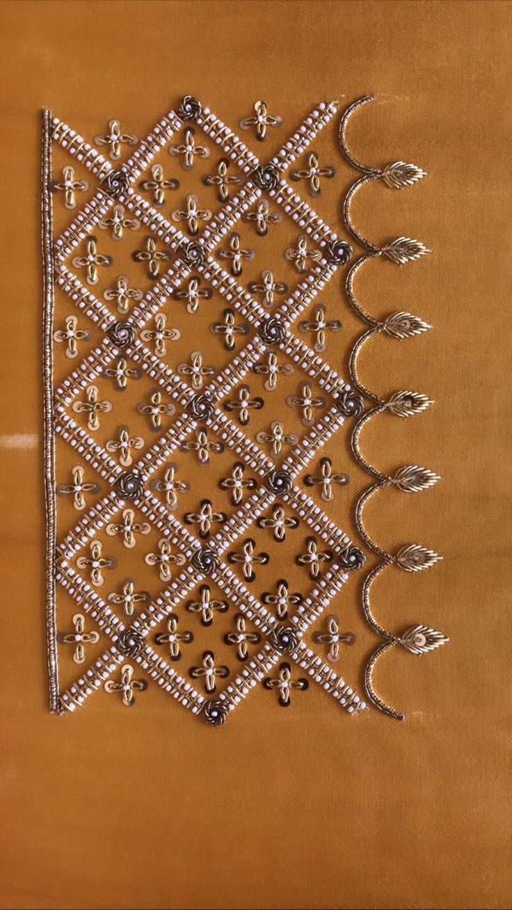 a piece of art made out of beads on a brown surface with white and black designs