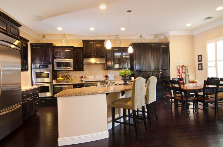 a large kitchen with dark wood cabinets and stainless steel appliances