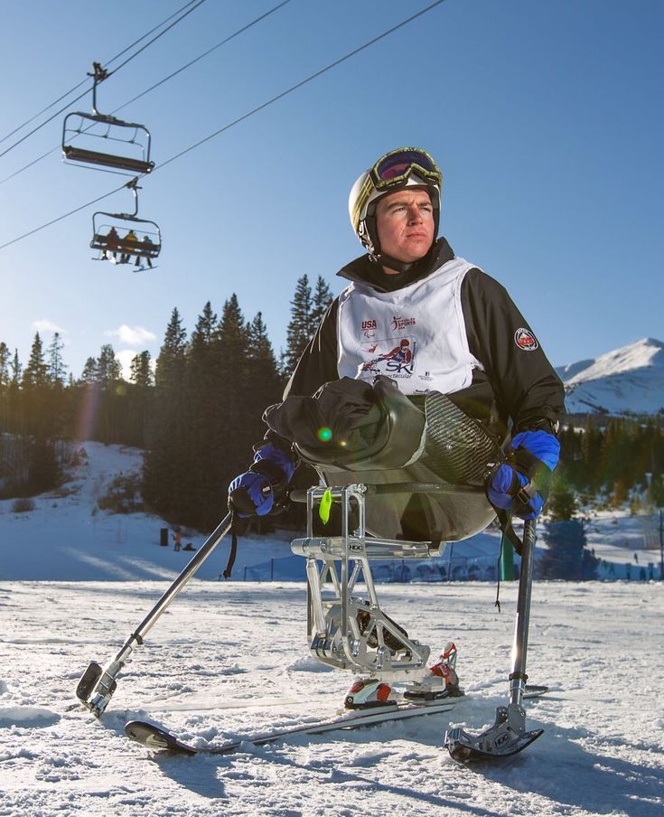 a man riding skis on top of a snow covered slope under a ski lift