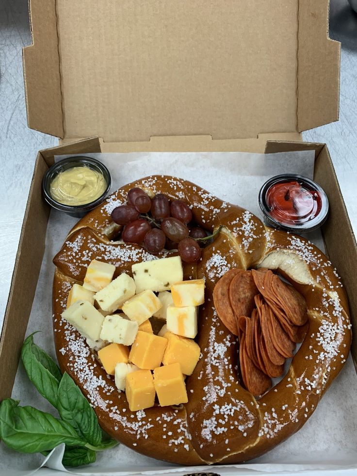 a box filled with lots of different types of cheeses and fruit on top of it