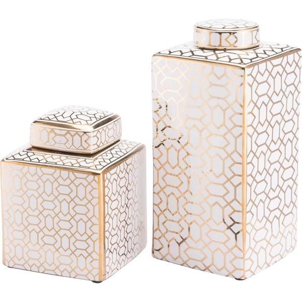 two white and gold canisters sitting next to each other on a white surface