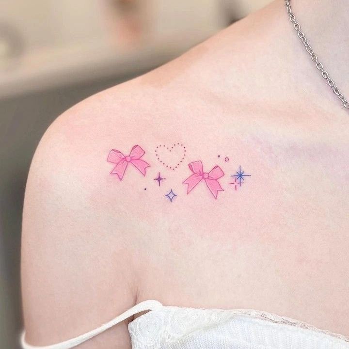 a woman's shoulder with pink bows and stars on her left side, which has the word love written across it