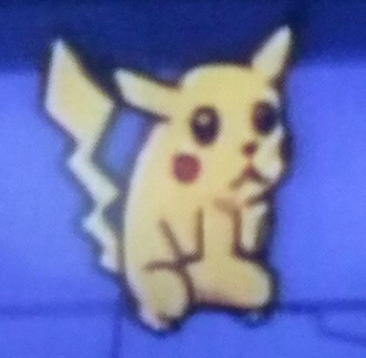 a close up of a pokemon pikachu on a blue surface with the background blurry