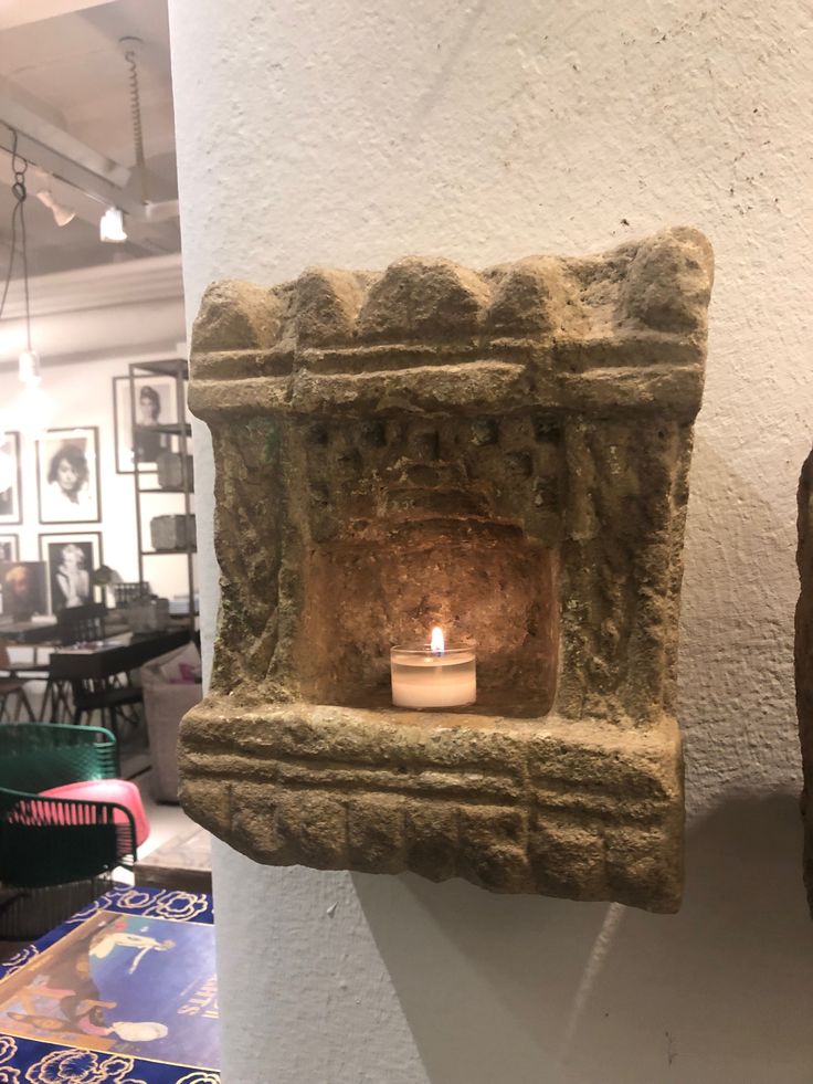 a stone fireplace with a lit candle in it