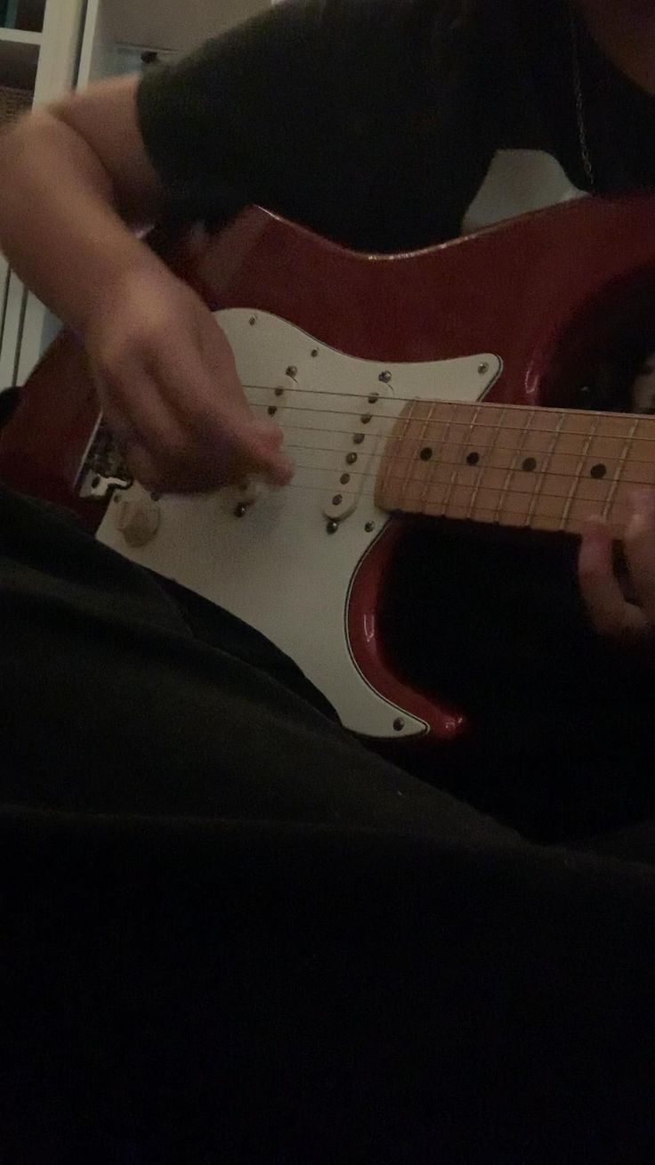 a man playing an electric guitar in his living room