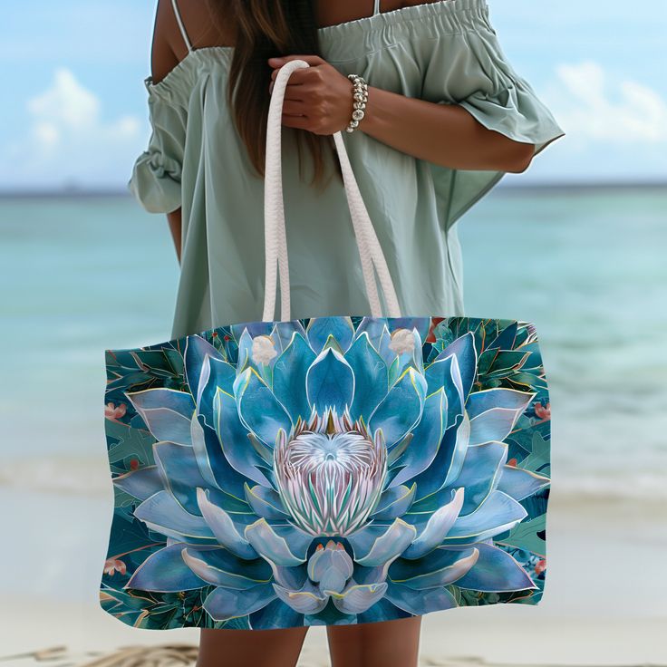 This elegant oversized tote is perfect for the beach or a weekend away. The wide-mouthed, durable bag holds a generous amount of personal items and is easily held by its thick rope handles. .: One size: 24" x13" (60.9 cm x 33 cm) .: 100% Spun Polyester .: T-bottom .: Cream sheeting interior lining .: NB! Size tolerance 0.75" (1.9 cm)) .: Assembled in the USA from globally sourced parts Blue Bohemian Beach Bag With Large Capacity, Beach Canvas Bag With Double Handle, Large Capacity Beach Tote Canvas Bag, Large Capacity Tote Canvas Bag For Beach, Large Capacity Canvas Tote Bag For Beach, Blue Double Handle Beach Bag For Travel, Blue Canvas Beach Bag For Shopping, Blue Canvas Bag For The Beach, Large Casual Summer Canvas Bag