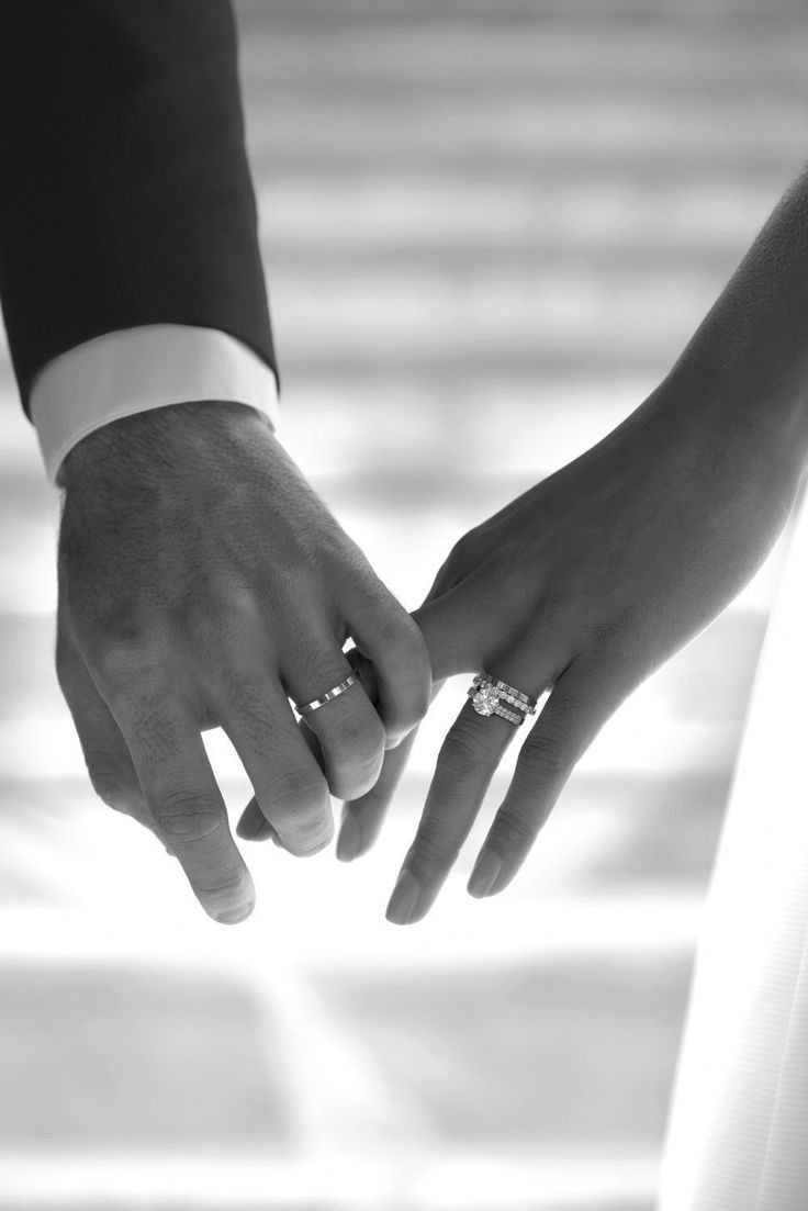 two people holding hands with their wedding rings