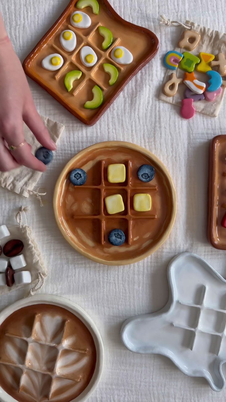 there are many desserts on the table with hands reaching for them to make one