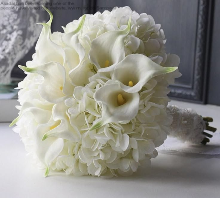 a bouquet of white flowers sitting on top of a table