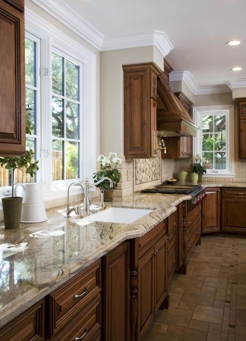 a kitchen with marble counter tops and wooden cabinets