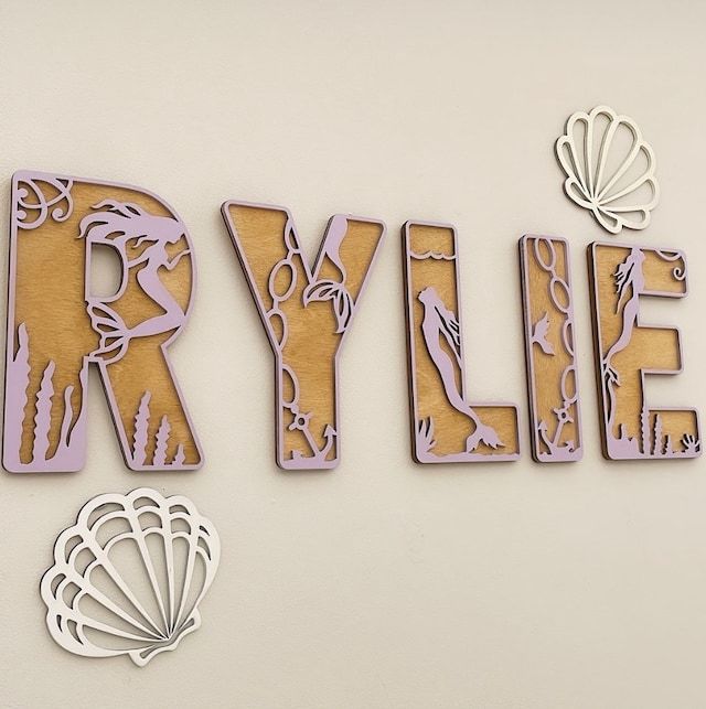 the word style is made out of wood and has an image of a mermaid on it