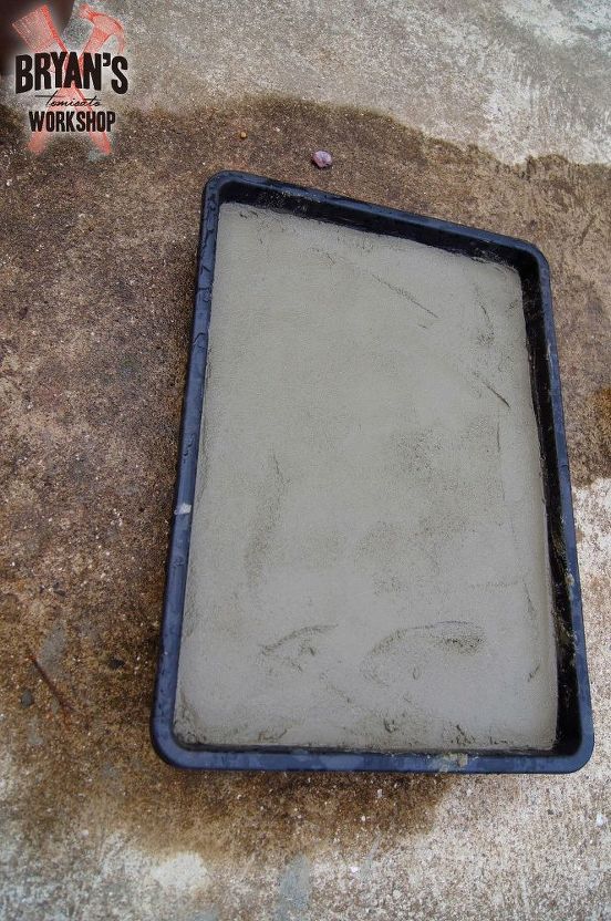 a cement pan sitting on top of a concrete floor next to a sidewalk with the words work shop written in it