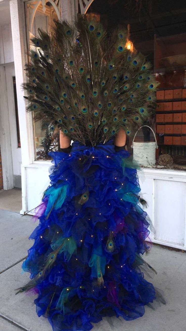 there is a blue dress with feathers on the front and back, as well as a peacock tail