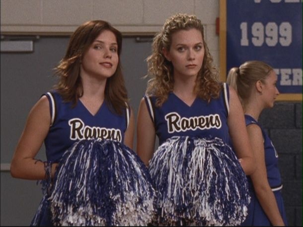 two young women in cheer uniforms standing next to each other