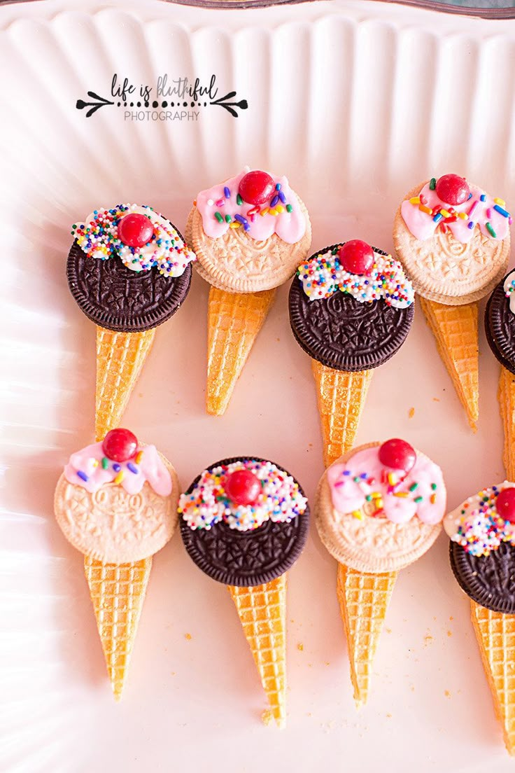 ice cream cones with sprinkles and cherries in them on a plate