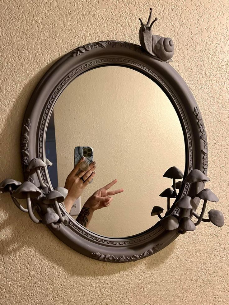 a person taking a selfie in front of a mirror with a snail on it