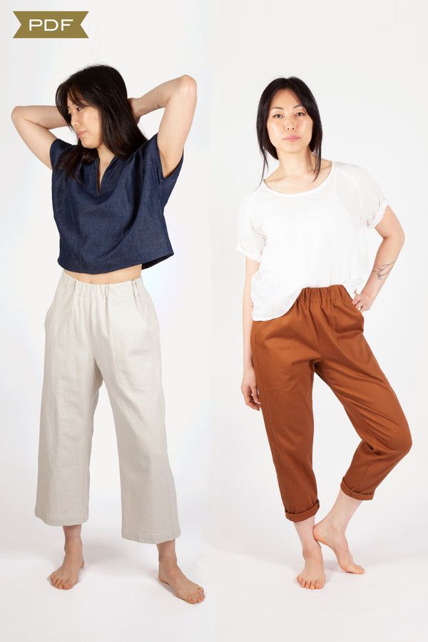 two women standing next to each other wearing pants and t - shirts with their hands on their head